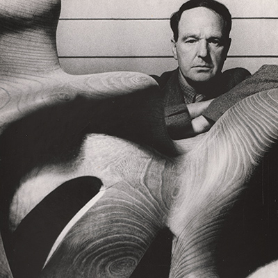 Black-and-white photograph of man with sculpture