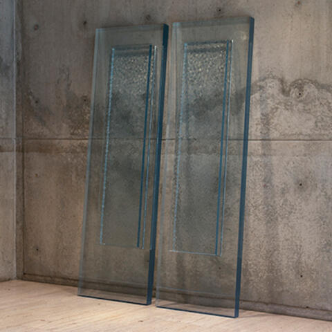 Two transparent panels leaning against concrete wall